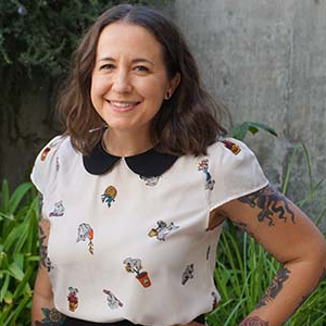 woman stands with hands on hips smiling