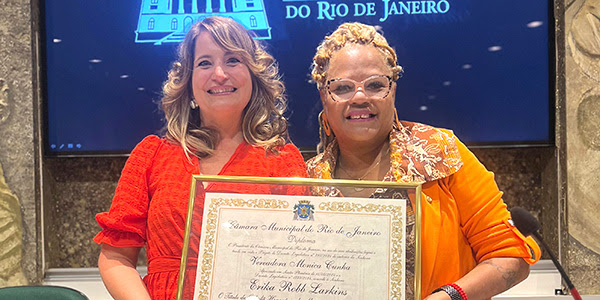 two women smiling holding award