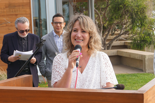 woman stands at podium and speaks