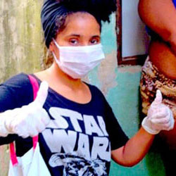 woman in favela wearing maks and gloves